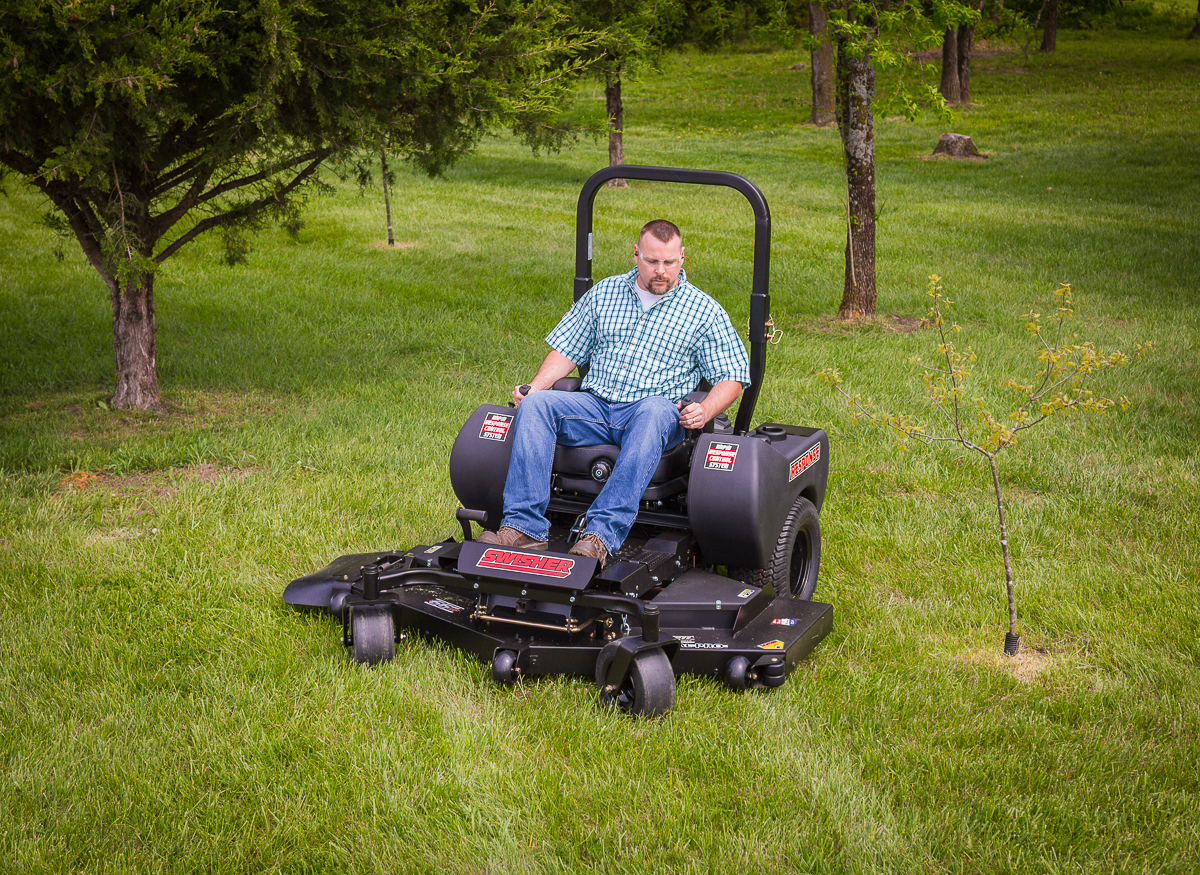A close-up view of the back wheel of a zero-turn mower. The mow is bright yellow and a little dirty.