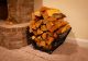 Firewood cradle full of firewood and sitting next to hearth of fireplace